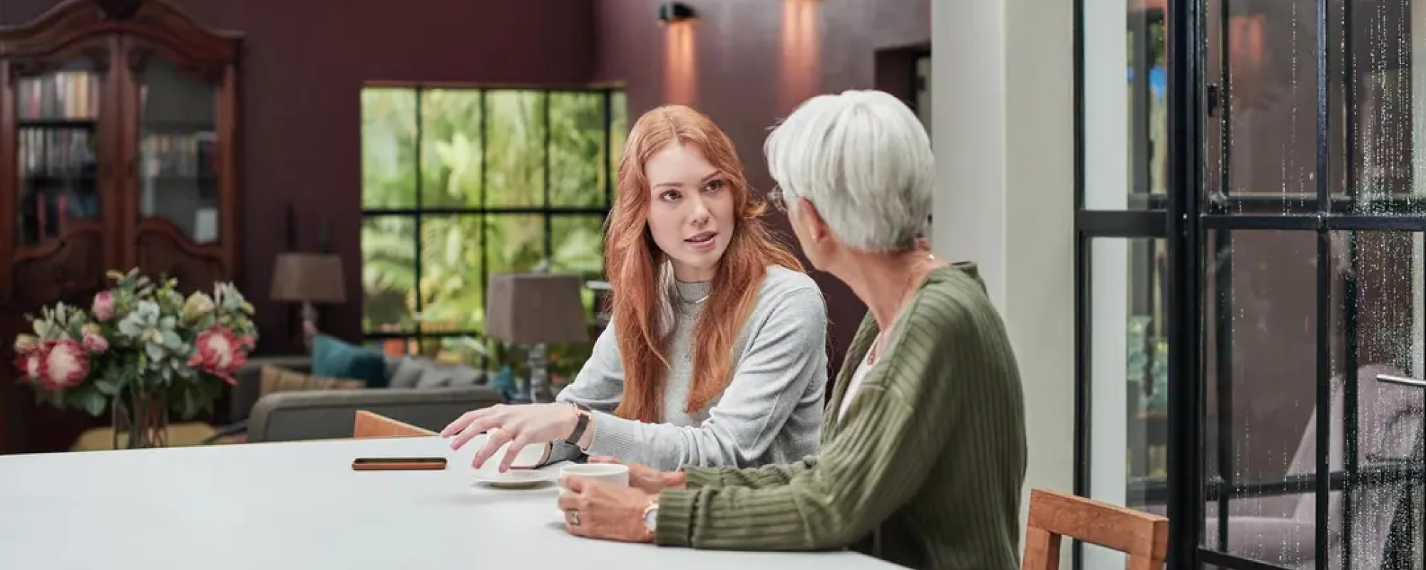 woman sitting at table with senior parent