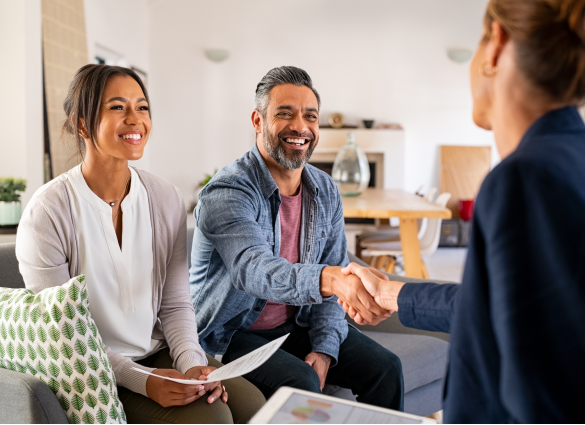man and woman shaking hands with lady in a suit