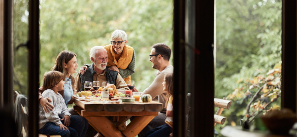 family of 6 eating at a picnic table in the woods
