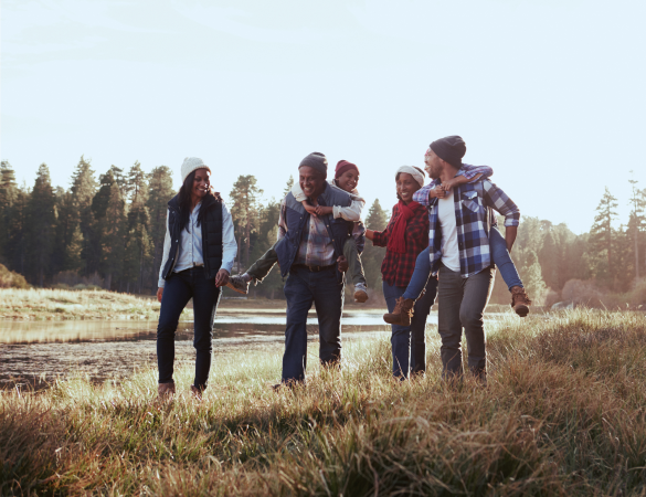 family of six walk through an open field