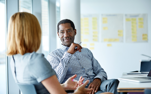 two people in an office speaking to one another