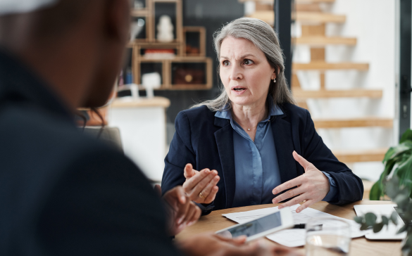 woman in suit speaking to someone out of frame