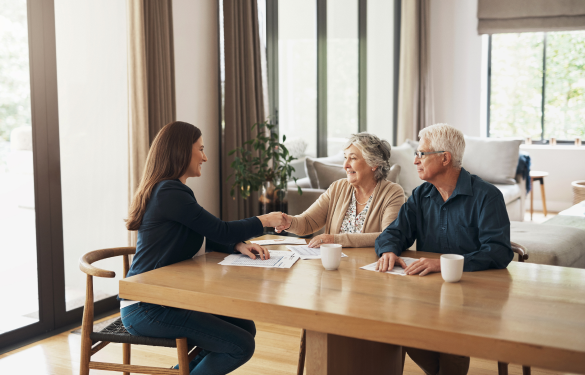 elderly couple shaking hands with a lady in a suit