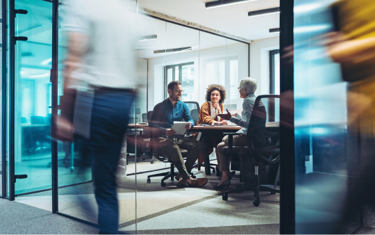 three people sitting in meeting room