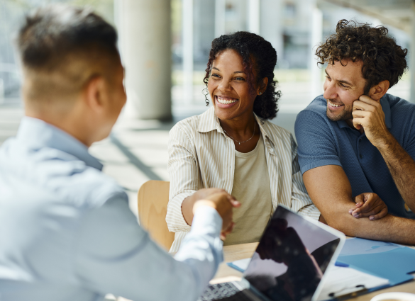couple shake hands with man sitting across from them