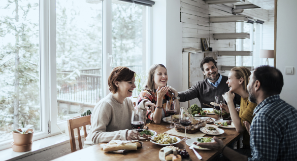 people laughing around dinner table