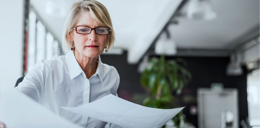 woman looking at papers on a desk