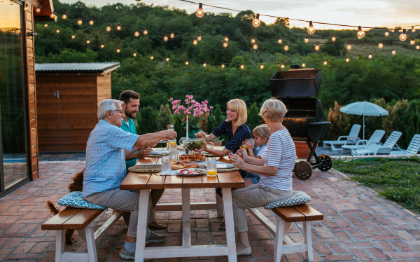 group of people sitting at a picnic table outside in the evening